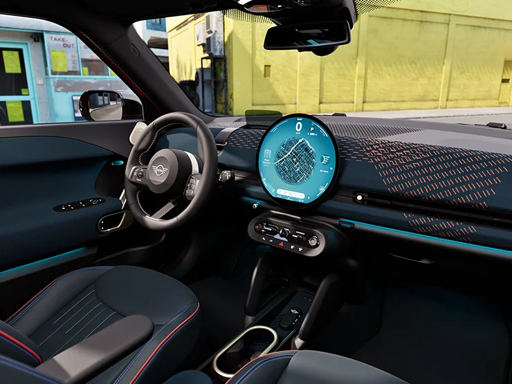 Interior view of the all-electric MINI Aceman focusing on the dashboard, the interaction unit and the steering wheel.