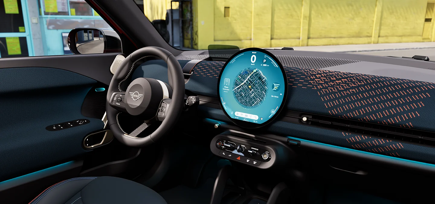Interior view of the all-electric MINI Aceman focusing on the dashboard, the interaction unit and the steering wheel.