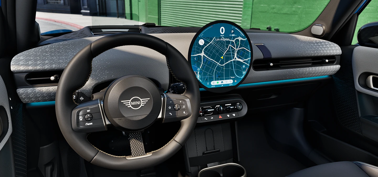 Interior view of the MINI Cooper 5-Door focusing on the steering wheel, the dashboard and the interaction unit.