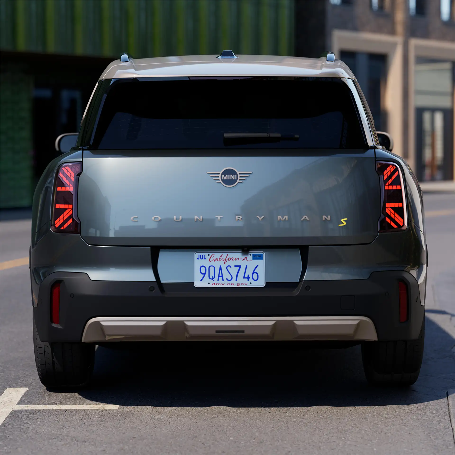 Rear view of a parking all-electric MINI Countryman in Smokey Green with Vibrant Silver Roof