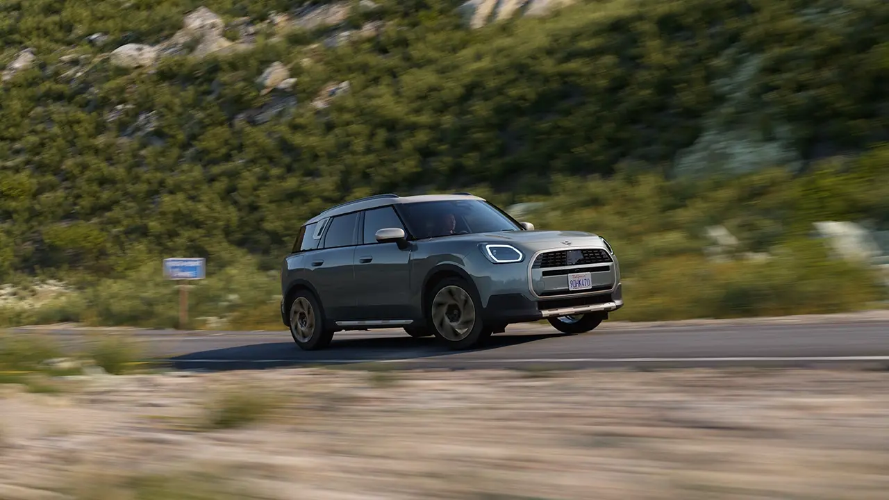 View of the MINI Countryman in Smokey Green and Favoured Style driving off-road