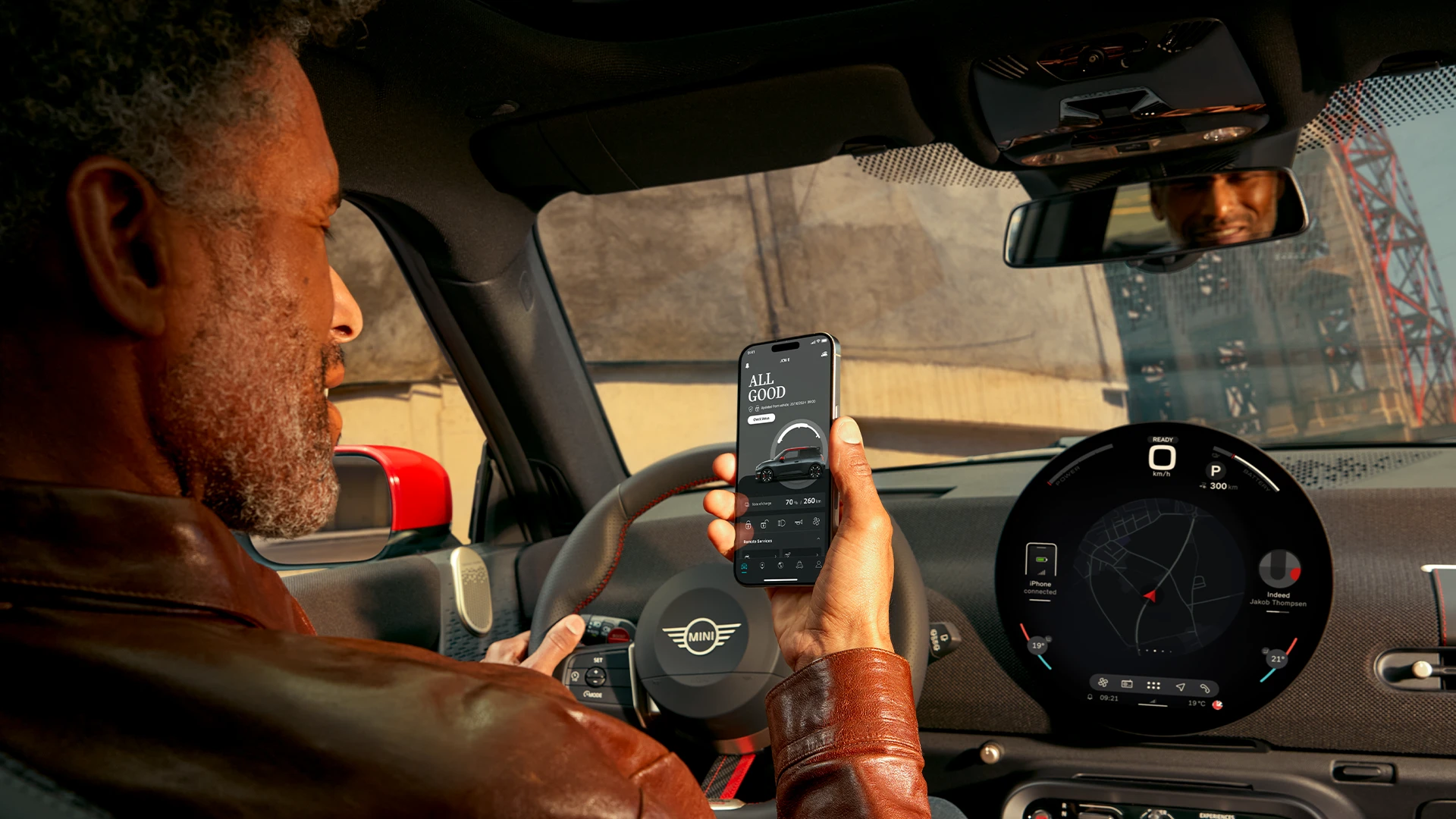 MINI driver using MINI App on his phone for navigation services.