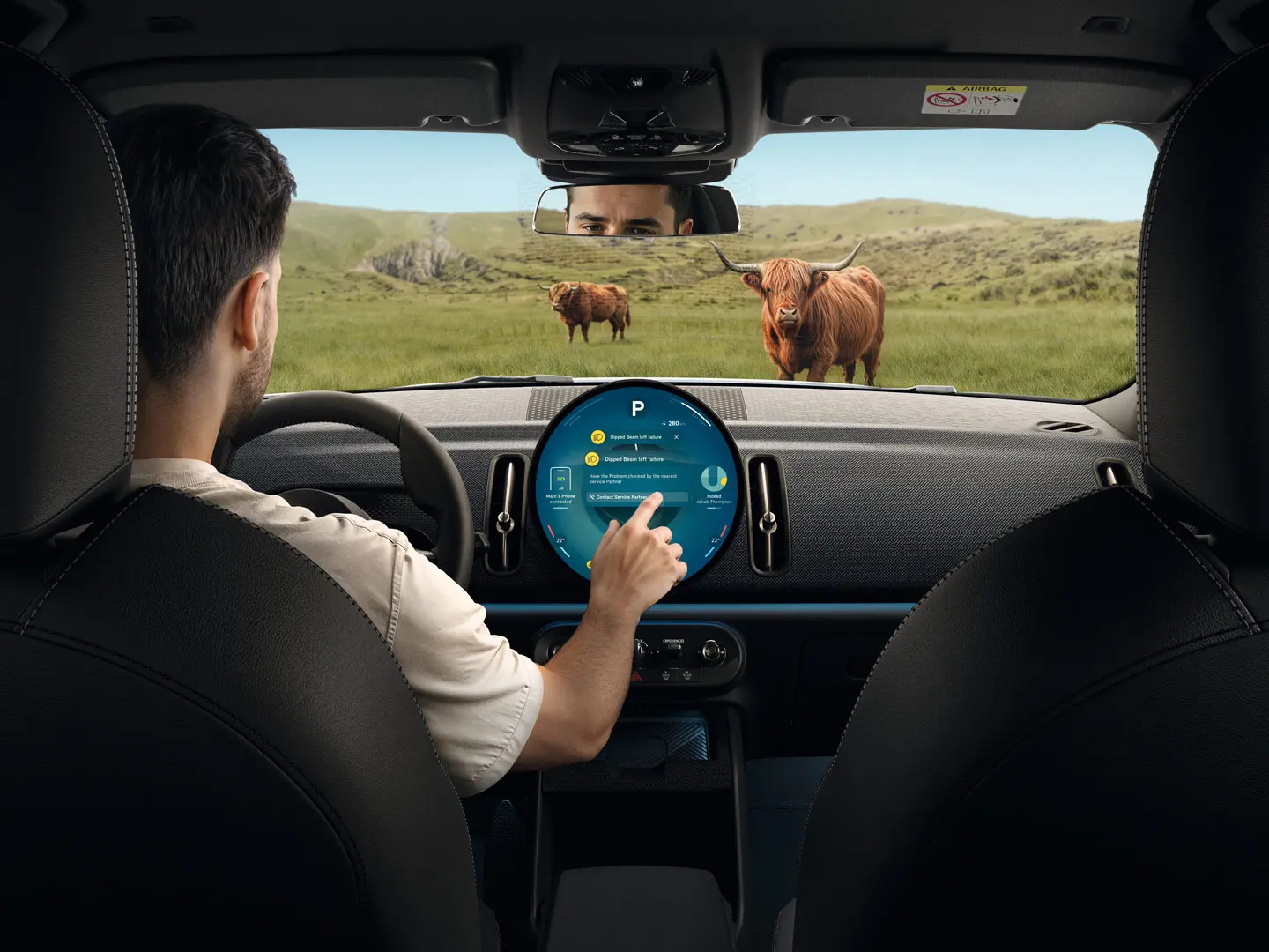 MINI driver on country road blocked by a Highland Bull getting advice from MINI Roadside Assistance via his touchscreen. 