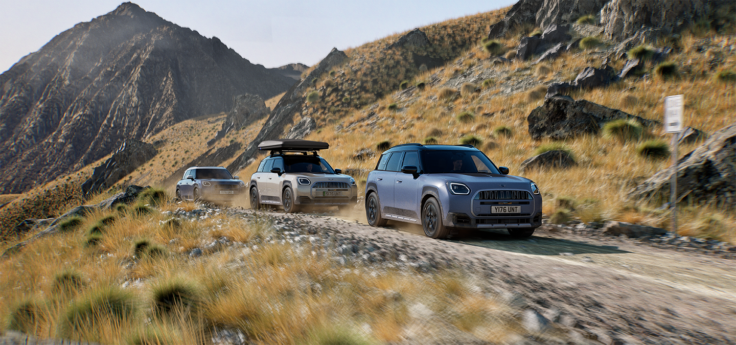 Image of multiple MINI Countryman Untamed Edition models driving on a rugged mountain road.