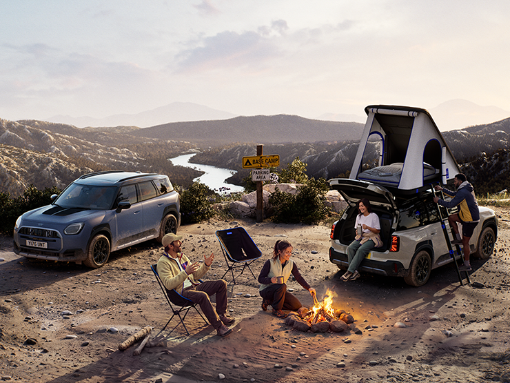 Image of two MINI Countryman Untamed Edition vehicles on a mountain at sunset.