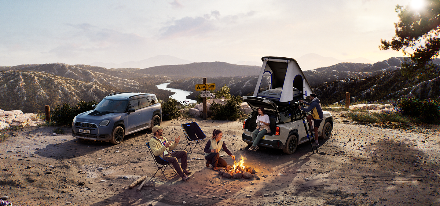 Image of two MINI Countryman Untamed Edition vehicles on a mountain at sunset.