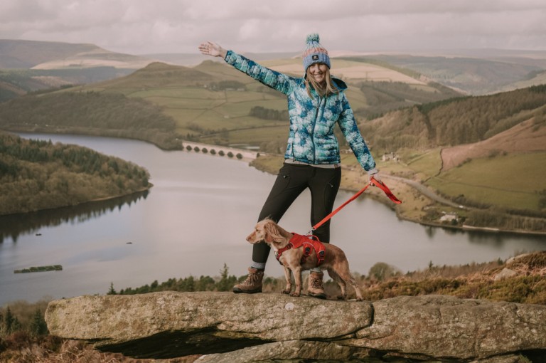 Woman with dog on a rock