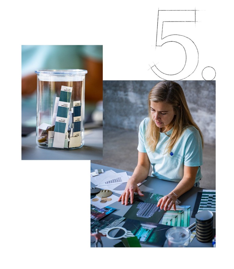 Strips of a Pantone formula guide in a glass. MINI CEM-Designer Evelin Hartmann working at her desk.