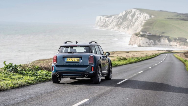 A blue MINI driving along a scenic coast road