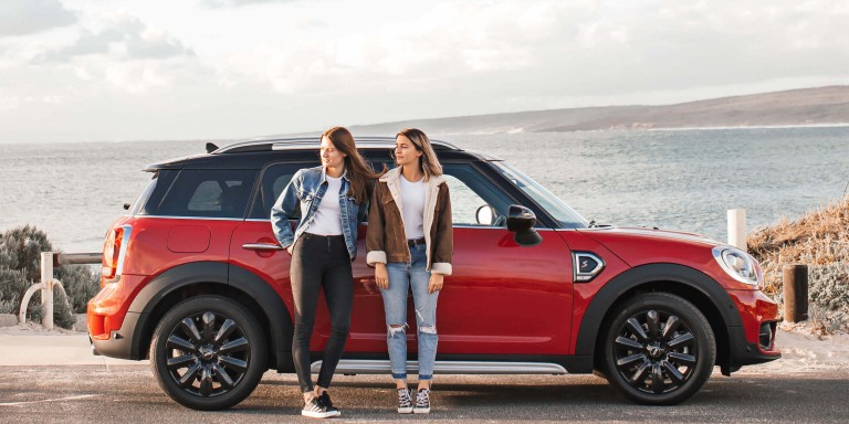 A red MINI with two woman standing in front