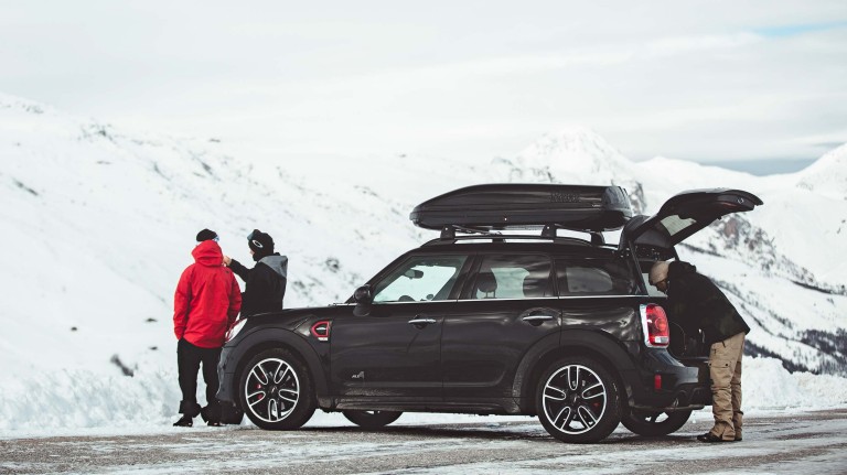A black MINI with snow mountains in the background