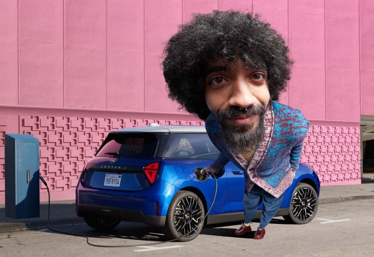 MINI Electric parked with man charging on street