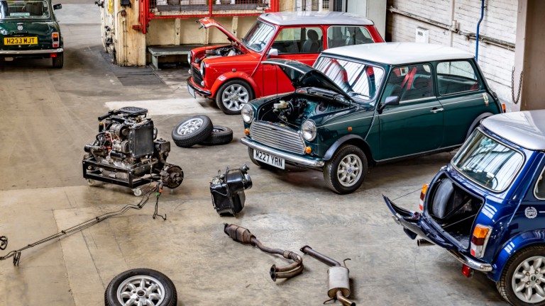 A MINI Cooper S in British Racing Green with two white racing stripes down the front – with racing flags in black and white and illustrations of people